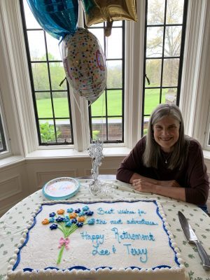 Lee sitting by cake celebrating retirement