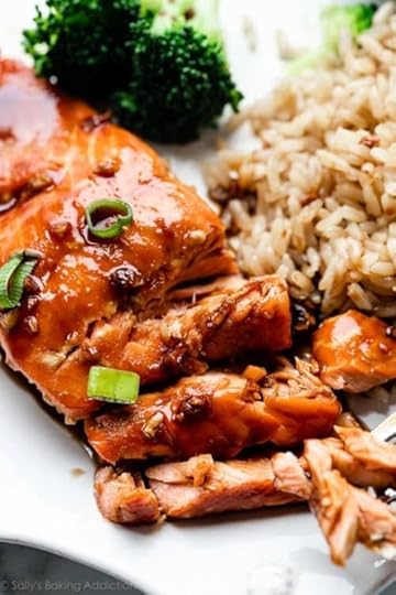 close-up of honey garlic soy glazed salmon with green onion, brown rice, and broccoli on plate.