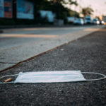 Close-up picture of a discarded protection face mask lying on the ground, COVID-19