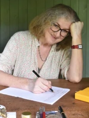 Debbie at writing desk with pen in hand