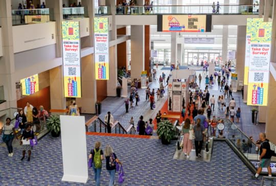 A wide shot of the main stairway in the convention center shows hundreds of festival goers