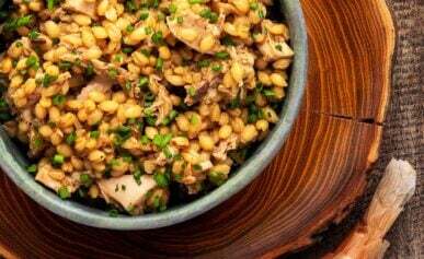 A bowl of barley risotto with mushrooms, onions and garlic.