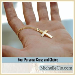 Right hand holding a gold personal cross