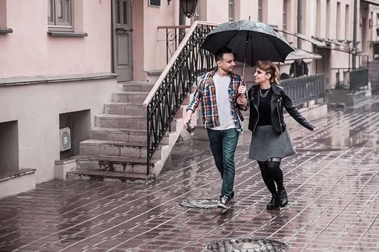 A couple walks under an umbrella on a rainy day