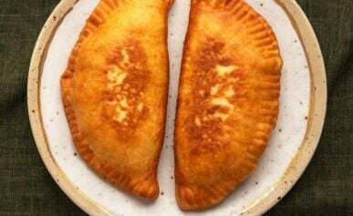 Two lihapiirakka, Finnish meat pies, on a plate.