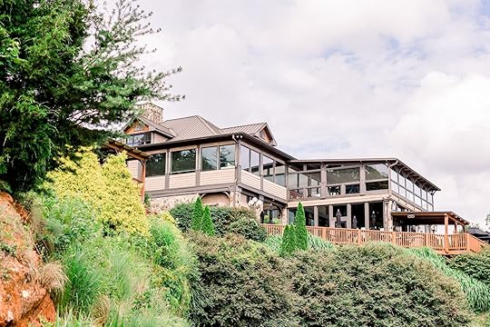 Wolf Mountain Vineyards tasting room on a hillside with green vegetation in foreground - Georgia wineries