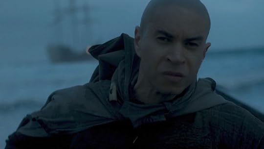 Laenor with a shaved head rows to a boat on House of the Dragon