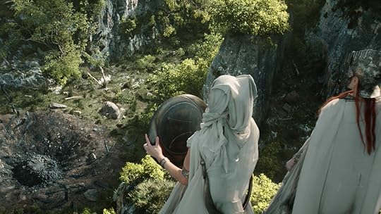 The Mystics stand over the site of the Syranger's meteor crash holding a shield with his constellation on The Rings of Power