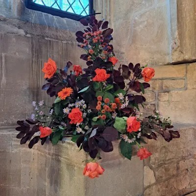 display of orange flowers and dark red foliage