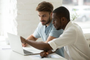 One colleague helping another colleague solve a problem