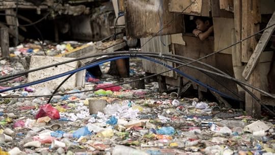 This photo taken on May 12, 2018 shows a boy looking out from a window of a house beside a garbage-filled creek in Manila. The blanket of trash on a creek that flows between the makeshift homes of a Manila slum is so dense it appears one could walk across it like a paved street. / AFP PHOTO / NOEL CELISNOEL CELIS/AFP/Getty Images