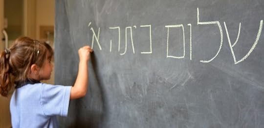 Girl writing Hebrew on a chalkboard