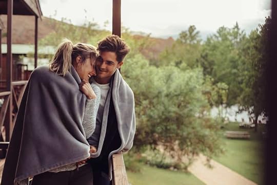 A couple on a balcony romantically sharing a blanket in Virginia