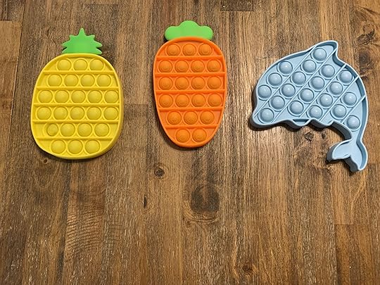 set of three pop fidget toys in the shape of pineapple, carrot, and dolphin toy for flight with toddler