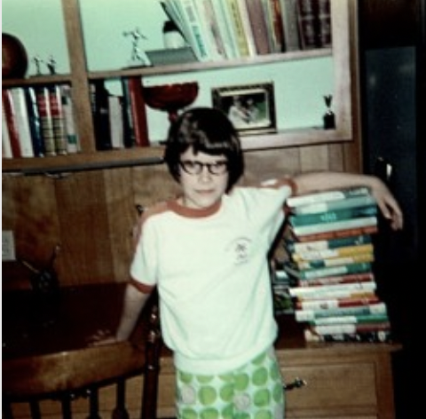 Lee as a kid with a large stack of library books