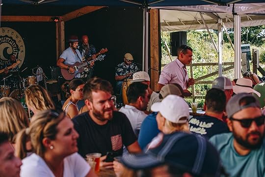 One of the best Massachusets breweries, Cisco Brewery, where band is playing a live show while people sit and drink beer
