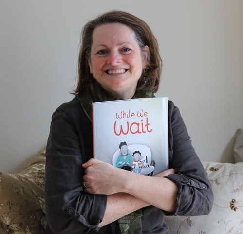 Judy Ann Sadler holding her picture book While We Wait