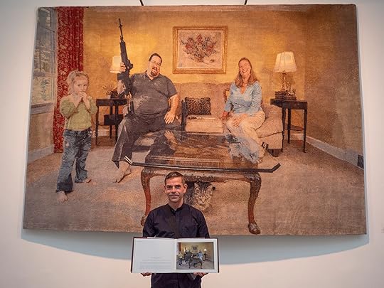Jan holding a copy of Armed America with the carpet he made out of one of the photos. 