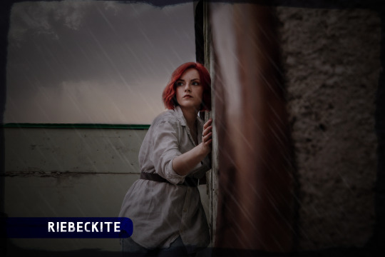 Red-haired woman standing pensively in the rain