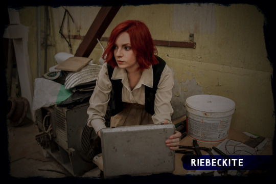 Red-haired woman opening box in an industial building