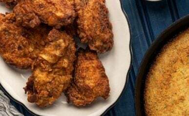 A platter of fried pheasant with pickles, cornbread and green beans.