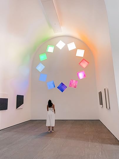 A woman in a white dress looks up at an exhibit in Blanton Musuem, of the things to do in Austin