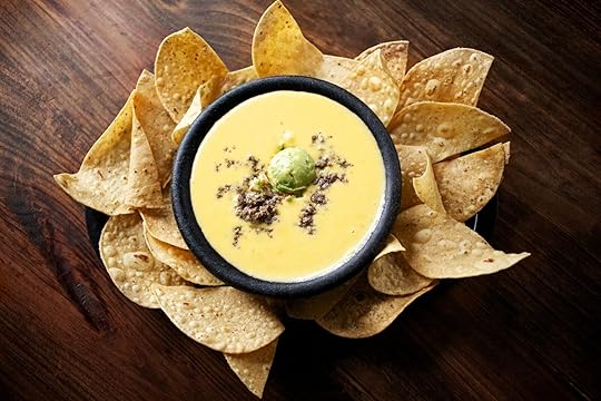A bowl of queso with gaucamole surrounded by a basket of chips at Matt's El Rancho in Austin