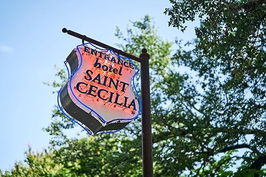 The red neon sign hanging outside of the Saint Cecilia Hotel in Austin