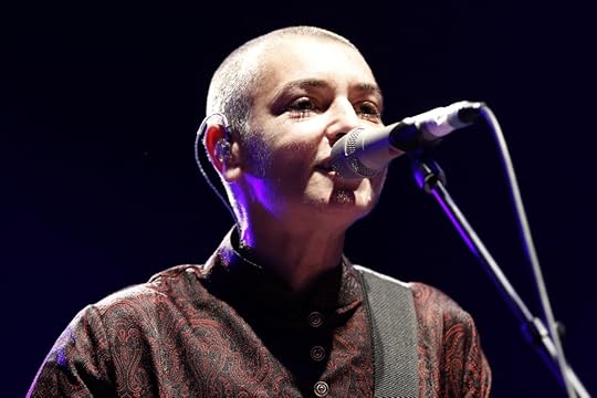 Sinead O'Connor singing into a mic on stage 
