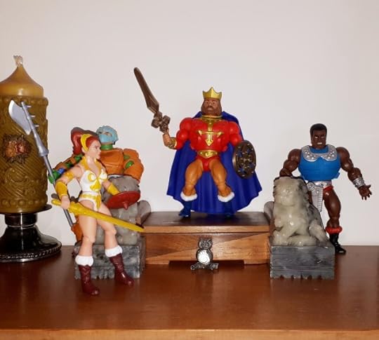 Teela enters the throne room, while King Randor is on his throne, flanked by Clamp Champ and a royal guard.