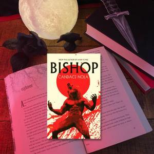 Bishop book in front of an open book, a full moon lamp, a black rose, a black crow, and a paper dagger bookmark