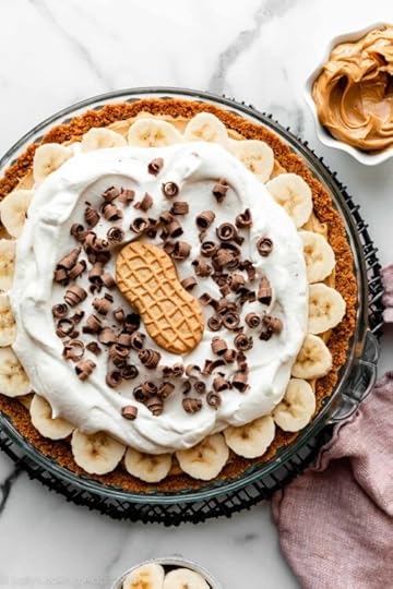 peanut butter banana cream pie with whipped cream, chocolate curls, and Nutter Butter cookie on top.