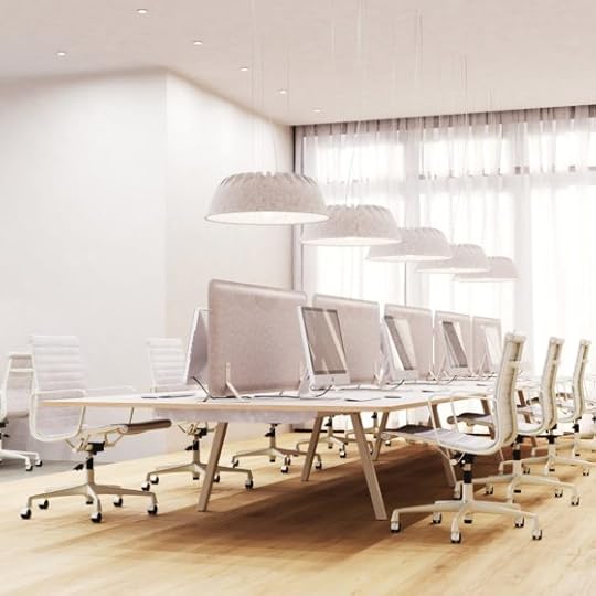 This is a product shot of a long table in an stark, white, modern office, each seat with its own computer, and above them the felt lamp shades that are the central point of the image.