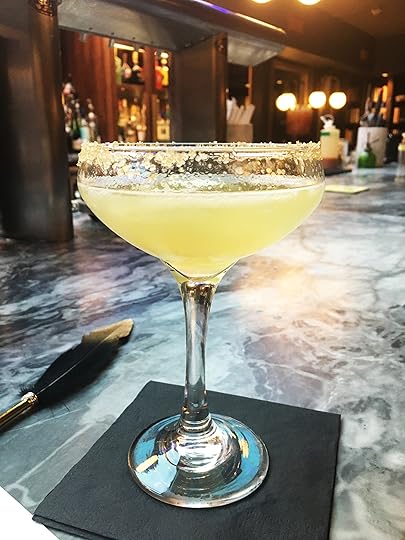 A Bee's Knees cocktail served during a 1920's themed party in a speakeasy.