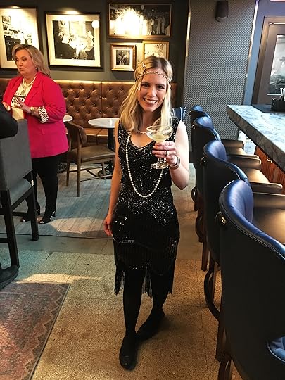 Female in 1920's style flapper dress holding a Bee's Knees cocktail.