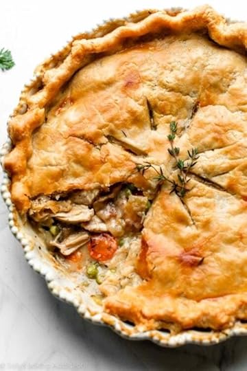 turkey pot pie with 1 slice removed to show carrots, peas, turkey, and gravy filling.