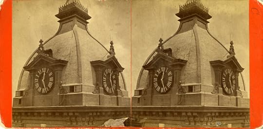 Black and white photo in sepia tones of two domes side by side. Each dome has two clocks with Roman numerals.