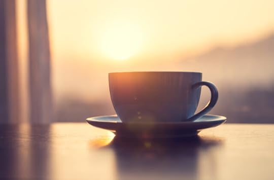 mug of coffee on table against the sunrise