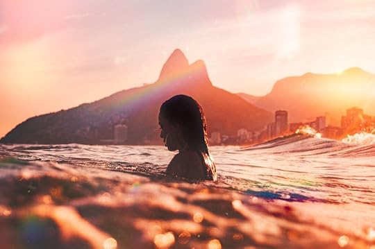 A mermaid emerging from the water in front of an island city
