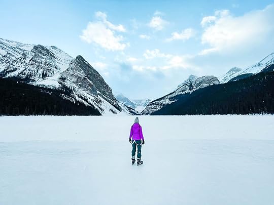 Person in purple jacket ice skating on a banff winter weekend because it's fun