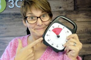 Liane holding up a countdown clock with 13 minutes remaining