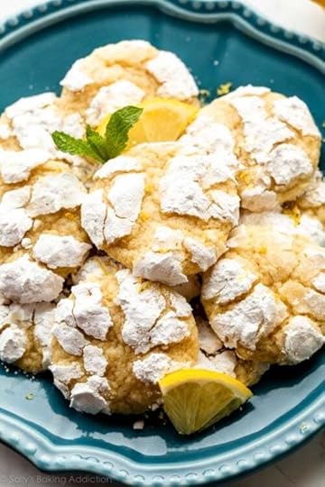lemon crinkle cookies arranged on blue plate with lemon slices and fresh mint.