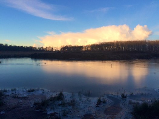 frozen loch with a sturdy pink and cream cloud above