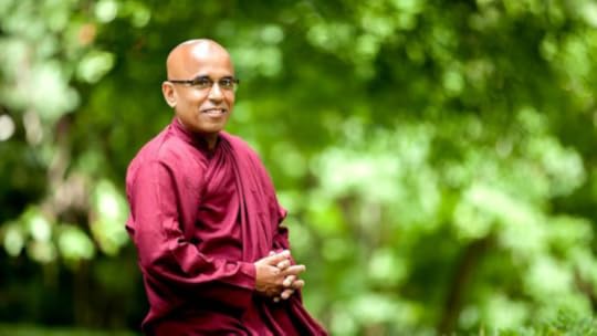 Buddhist monk Bhante Sujatha against a blurred background of greenery