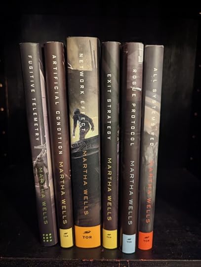 The Murderbot book series by Martha Wells sitting on a shelf.
