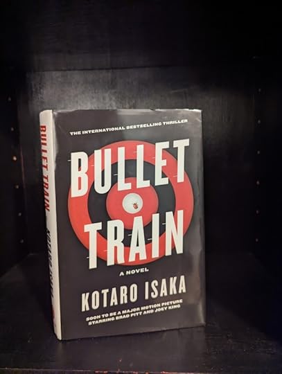 The hardback cover edition of the book Bullet Train by author, Kōtarō Isaka. The dust jacket of the book has a black background with a red and black target and a white bullseye.