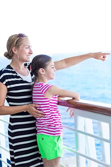 A mother and daughter are on a ship balcony looking out over the water