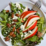 overhead shot of pear salad with candied almonds and blue cheese.