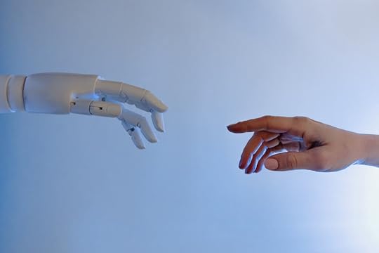 Photo of a robot hand reaching out to a human hand, taken by Tara Winstead.