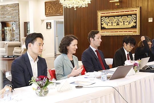 Picture of women and men sitting at a long table with latops